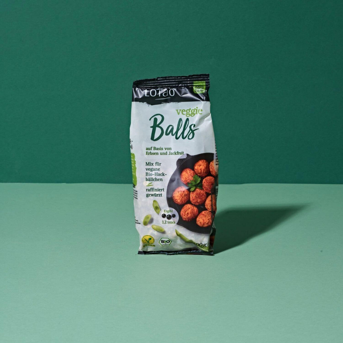 100g Packung vom Lotao Veggie Balls Mix, dem veganen Fleischersatz auf Basis von Jackfruit und Erbsen für saftige vegetarische Hackbällchen in Bio-Qualität vor grünem Hintergrund