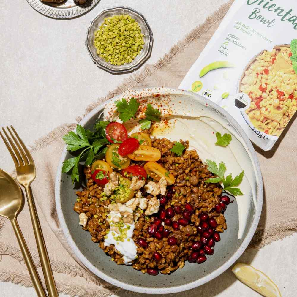 Veggie Orientalische Bowl von Lotao angerichtet mit Tomaten und Granatapfel für den schnellen und einfachen Genuss in veganer Bio-Qualität